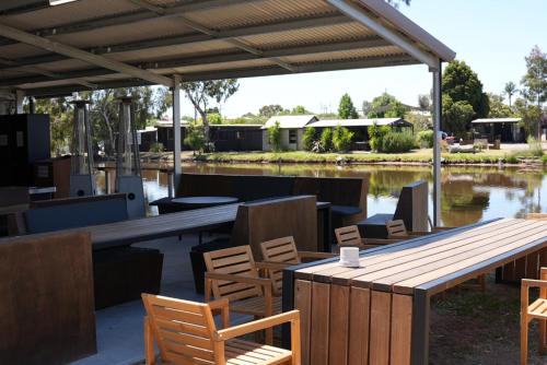 a patio with a wooden table and chairs and water at Backpacker, Worktime Accommodation at C & C in Stawell