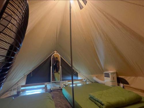 a tent with a bed and a person in it at Amar Camp Taman Negara Kuala Tahan in Jerantut