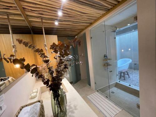 un vase de fleurs sur une table dans une salle de bain dans l'établissement New Villa with bathtub and Jacuzzi, à Tulum