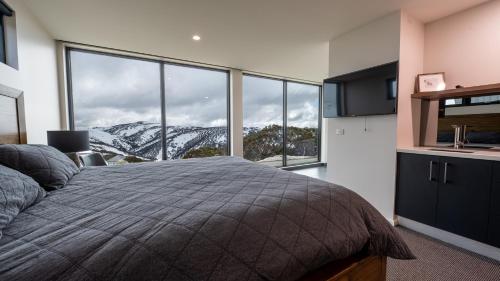 a bedroom with a bed with a view of a mountain at Whitemount in Mount Hotham