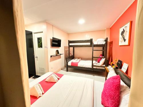 a small room with two beds and a bunk bed at Sukhavati Inn in Baguio