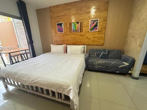 a bed and a couch in a room at Jingle Bells Resort in Ko Larn