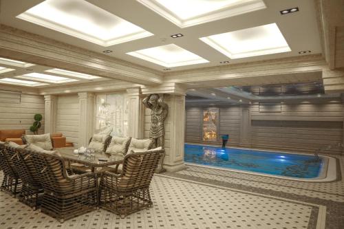 a living room with a swimming pool and a table and chairs at Aliz Boulevard Hotel in Samarkand