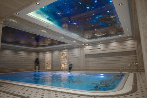 a swimming pool in a building with a star ceiling at Aliz Boulevard Hotel in Samarkand
