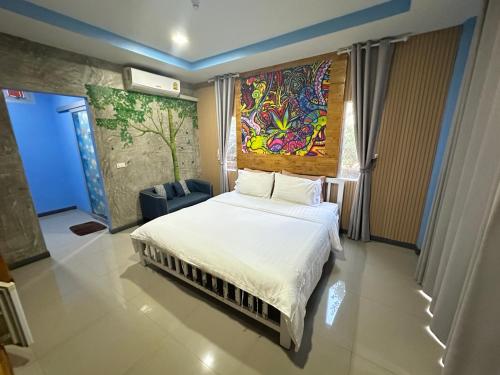 a bedroom with a bed and a painting on the wall at Jingle Bells Resort in Ko Larn