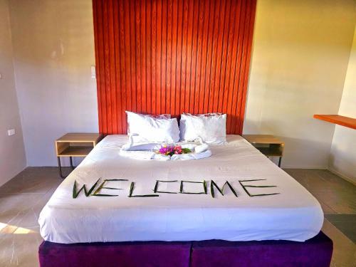 a bedroom with a bed with a welcome sign on it at Pacific Harbor B&B in Pacific Harbour