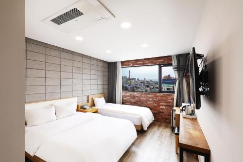 a hotel room with two beds and a television at Diamond hotel wolmido in Incheon