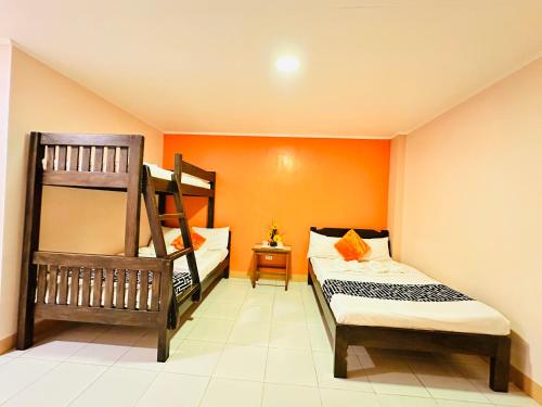 a bedroom with two bunk beds and an orange wall at Sukhavati Inn in Baguio