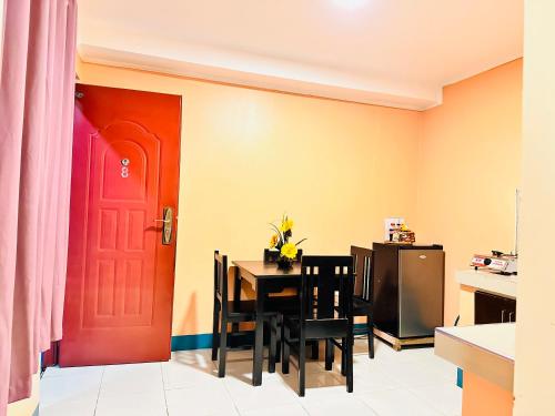 a kitchen with a red door and a table with chairs at Sukhavati Inn in Baguio