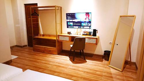 a bedroom with a desk with a mirror and a chair at PLUM Dreamscape Bhagia Malioboro in Sentool