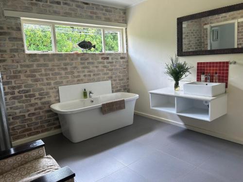 a bathroom with a white tub and a sink at The Good Earth Farm in The Crags