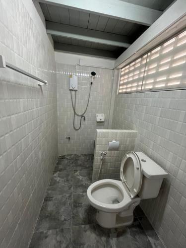 a bathroom with a toilet and a shower at The Neighbors in Chanthaburi