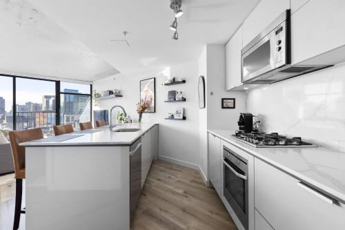 a kitchen with white counters and a stove top oven at Luxury Central Apartment with City Views in Vancouver
