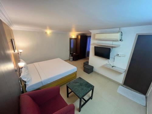 a room with a bed and a couch and a tv at Hotel City Tower, Chennai Central in Chennai