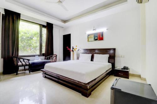 a bedroom with a bed and a desk and a window at Blue Moon Residency Hotel & Restaurant in Gurgaon