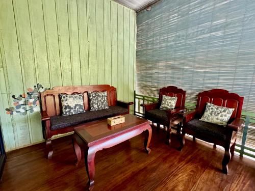a living room with two chairs and a coffee table at Mes trois coeurs in Phumĭ Réach Born