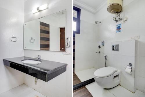 a bathroom with a toilet and a sink and a mirror at Blue Moon Residency Hotel & Restaurant in Gurgaon