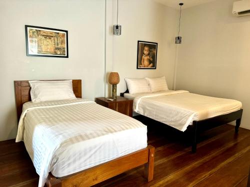 a room with two beds and a table at Mes trois coeurs in Phumĭ Réach Born