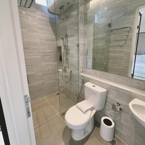 a bathroom with a toilet and a glass shower at Cerita di Villa - Your Second Home in Batu in Tlekung