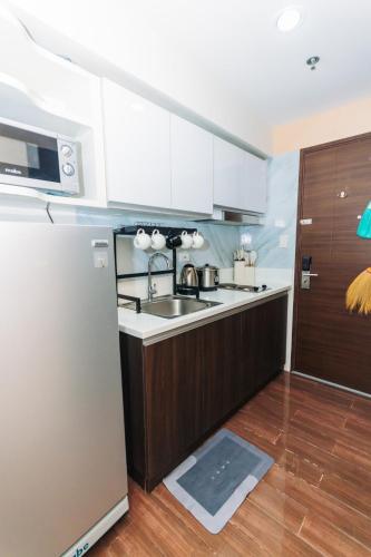 a kitchen with a sink and a refrigerator at City Chill Spot Where Style Meets Smiles Swim Gym Park 1765 in Manila
