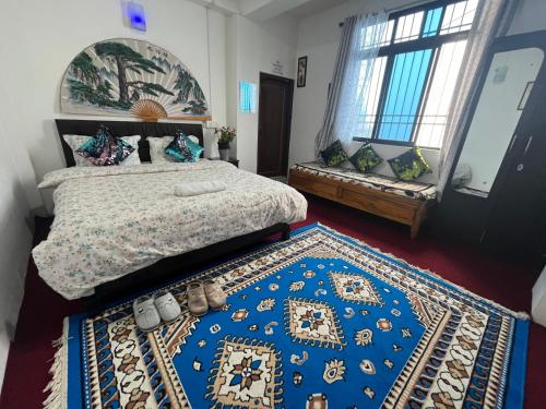 a bedroom with a bed and a blue rug at shalom inn home stay in Darjeeling