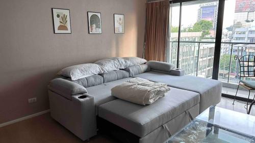 a living room with a couch and a large window at convenient&peaceful place in Soi nai leot in Bangkok