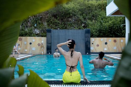 a woman in a swimsuit sitting in a swimming pool at The Merlin's Groove in Udaipur