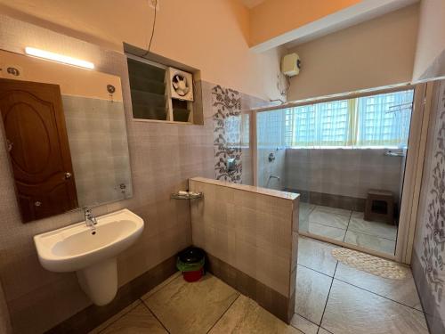 a bathroom with a sink and a shower at Karapuzha Village Resort in Wayanad