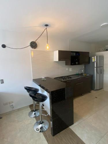 a kitchen with a black counter and a refrigerator at Apartamento En Villa del Prado in Cali
