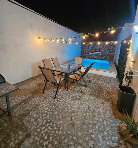 a patio with a table and chairs and a pool at Departamento con piscina GREEN in Mérida