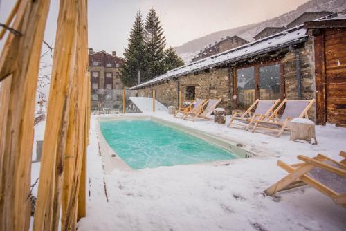 a swimming pool covered in snow next to a building at Mountain Hostel Tarter in El Tarter