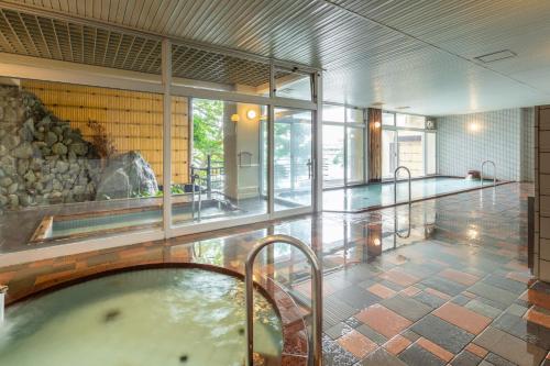 a large room with a bath tub in a building at Todaya in Toba