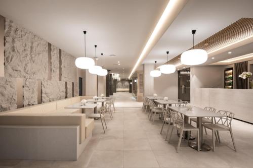 a restaurant with tables and chairs and lights at Aqua Perla Boutique Hotel in Chişinău