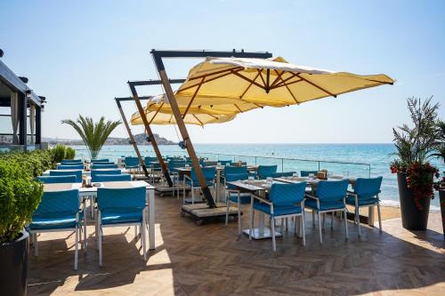 un restaurante con sillas y mesas azules y una sombrilla amarilla en Four Seasons Life Official, en Iskele