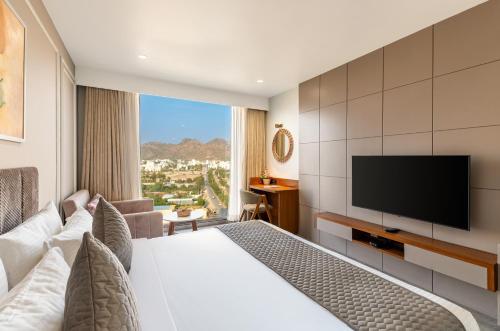 a hotel room with a bed and a flat screen tv at The Paradise Bliss - A Luxury Hotel & Spa in Udaipur in Udaipur