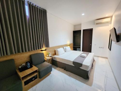 une chambre d'hôtel avec un lit et une chaise dans l'établissement Pondok Labu Residence, à Jakarta