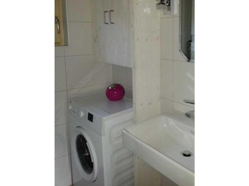 a bathroom with a washing machine and a sink at Blum - vom Ende Comfortable holiday residence in Altmünster