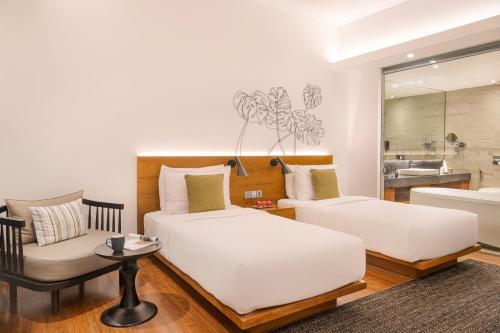 a hotel room with two beds and a couch at Jetwing Colombo Seven in Colombo