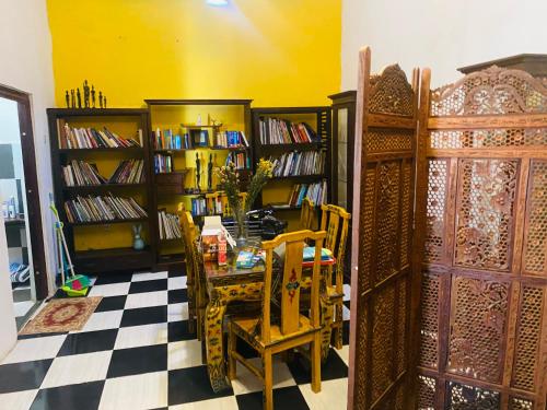a room with a table and chairs and book shelves at Apartament 60 m2 in Dili