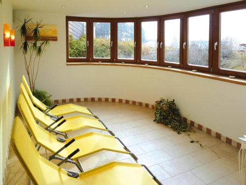 a waiting room with yellow chairs and windows at Farmhouse on Mieminger Plateau with Mountain Views in Mieming