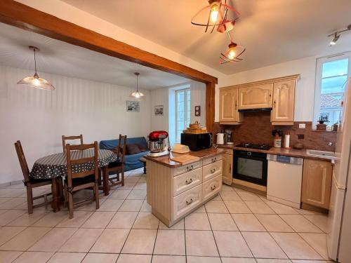 une cuisine avec une table et une salle à manger dans l'établissement Maison du canton proches commerces, à Grand-Village-Plage