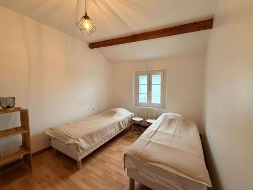 une chambre avec deux lits et une fenêtre dans l'établissement Maison du canton proches commerces, à Grand-Village-Plage
