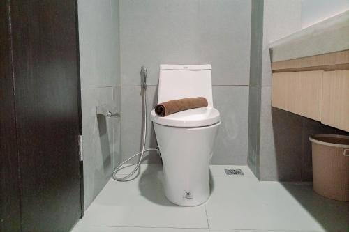 a bathroom with a toilet with a towel on it at Great Deal and Homey Studio Room Patraland Amarta Apartment By Travelio in Beran-kidul