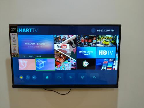 Un televisor de pantalla plana colgado en una pared en Shri Rajadhiraj Ashray- Nr Mathura Railway Station, en Mathura
