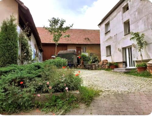 a garden in front of a building with flowers at Farm Privatzimmer Reni Gemeinschaftsbad Free WiFi Naturgarten in Hausbreitenbach