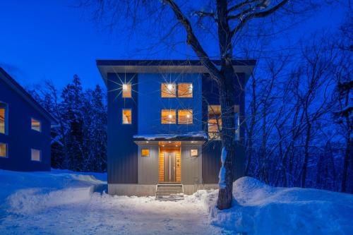 a house in the snow at night at Bluebird Chalets by The Hakuba Collection in Hakuba