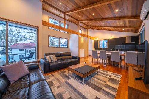 a living room with a couch and a table at Bluebird Chalets by The Hakuba Collection in Hakuba
