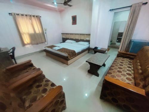 a room with two beds and a couch in it at Hotel Apsara, Koraput in Jaypur