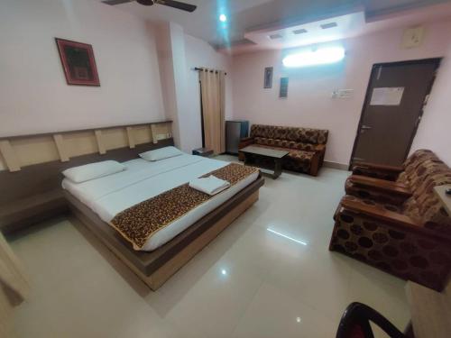 a bedroom with a bed and a couch in a room at Hotel Apsara, Koraput in Jaypur