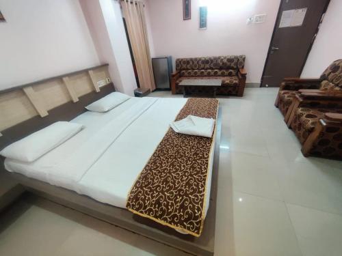 a bedroom with a large bed and a couch at Hotel Apsara, Koraput in Jaypur